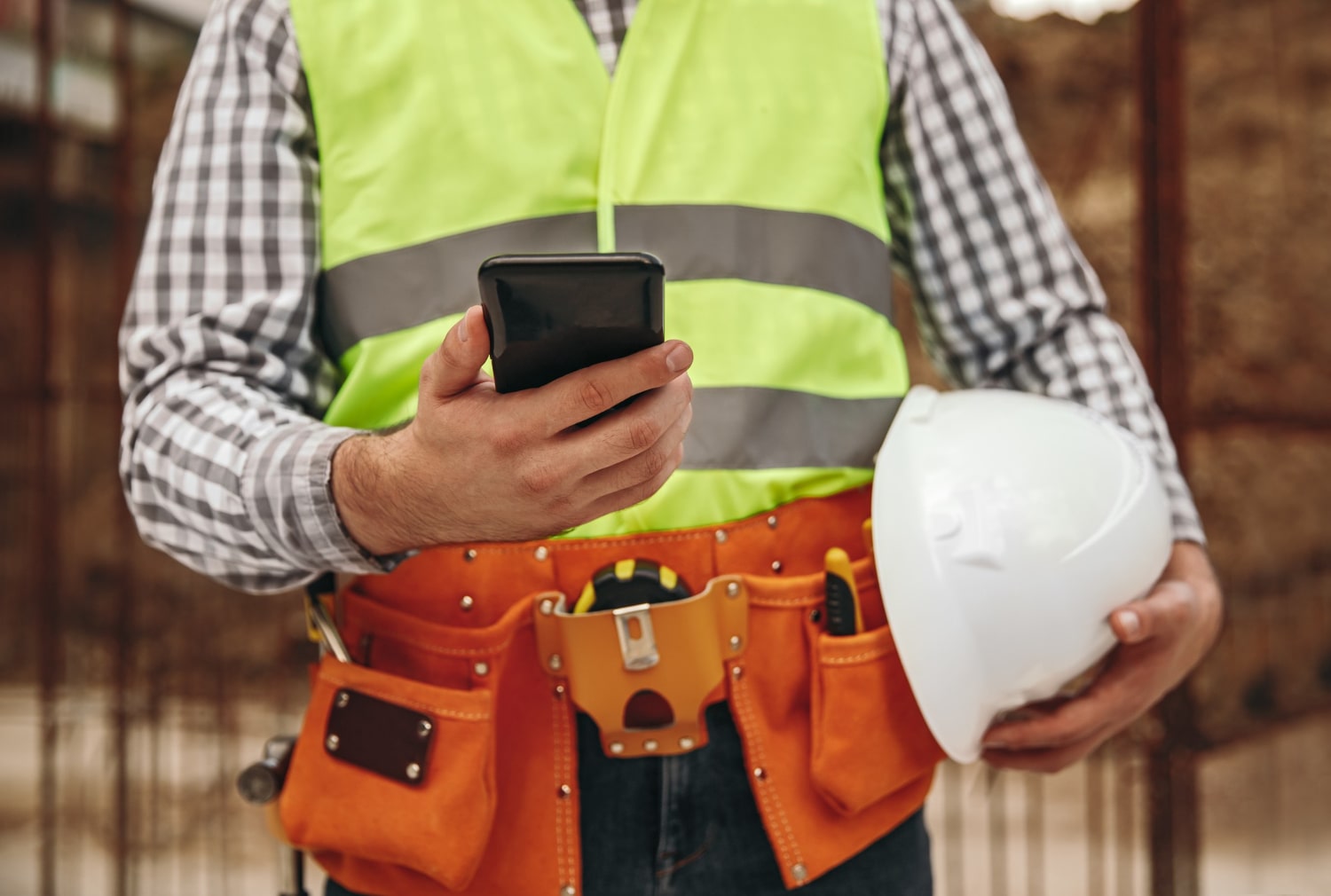 Bauarbeiter auf Baustelle nutzt App für moderne Workflows auf dem Bau